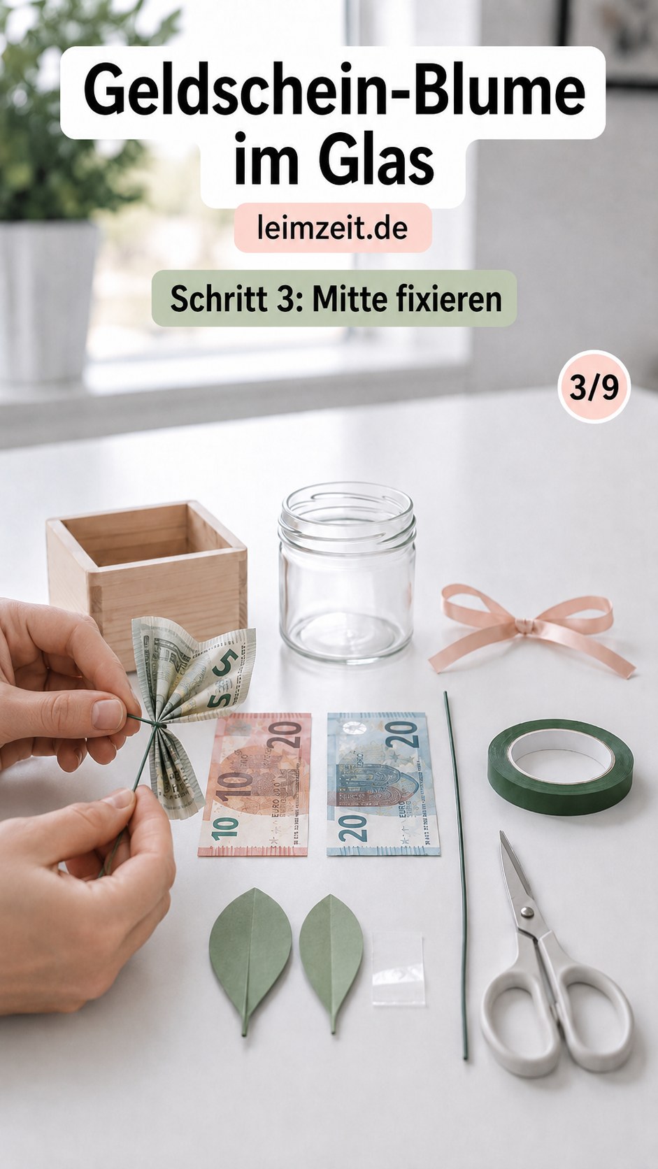 Die Mitte des gefalteten Scheins wird mit Draht fixiert, ein zentraler Schritt der Geldschein-Blume im Glas