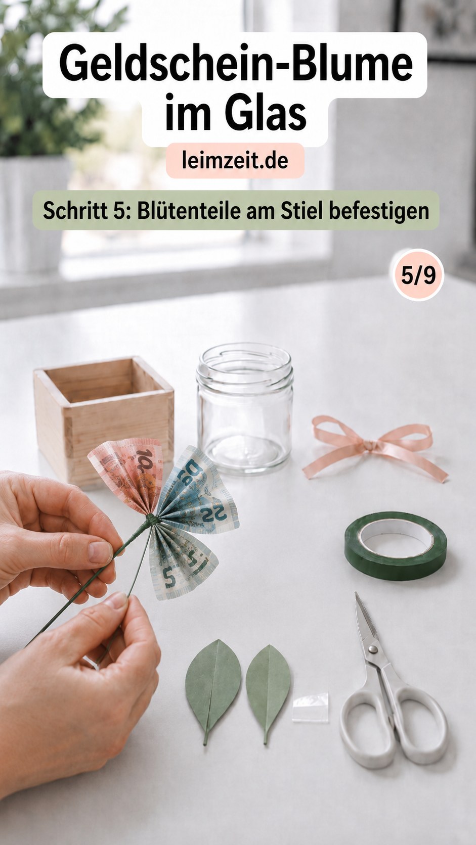 Die gefalteten Blütenteile werden am grünen Blumendraht als Stiel der Geldschein-Blume im Glas befestigt