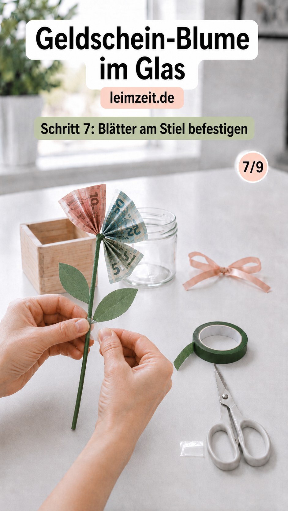 Zwei Stoffblätter werden seitlich am Stiel der Geldschein-Blume im Glas angebracht und fixiert