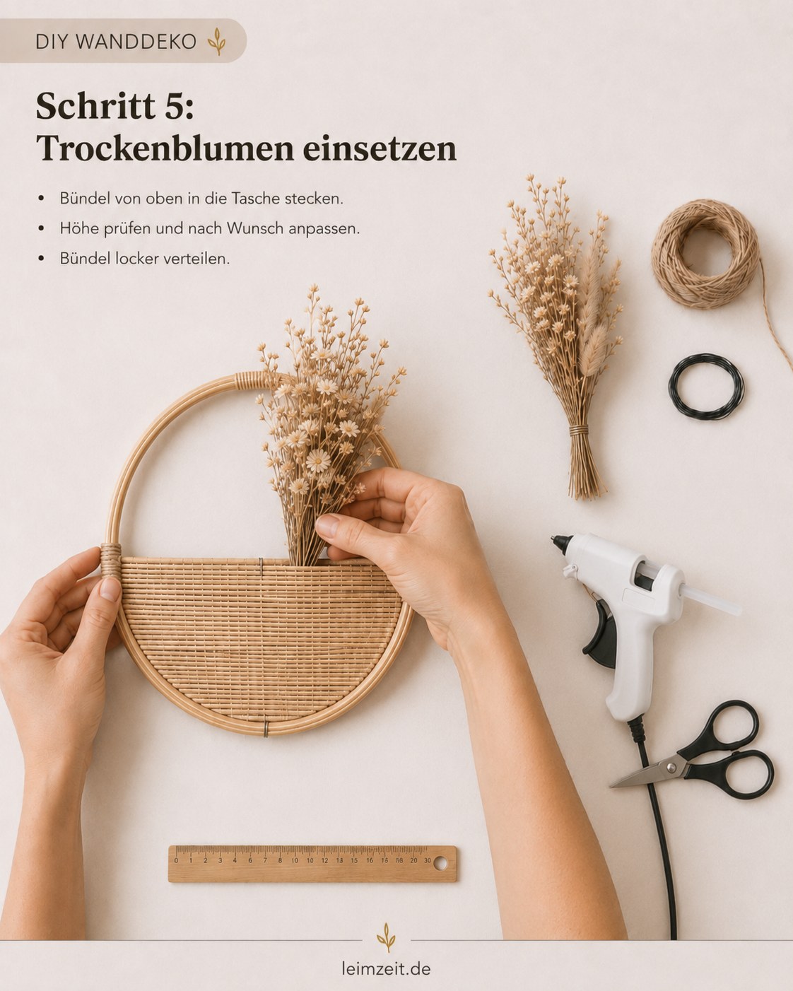 Erstes Trockenblumenbündel wird von oben in die Geflechttasche der runden Wanddeko gesteckt